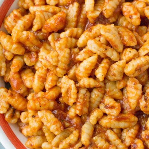 A close up of Homemade Ricotta Cavatelli in a red lined pasta bowl