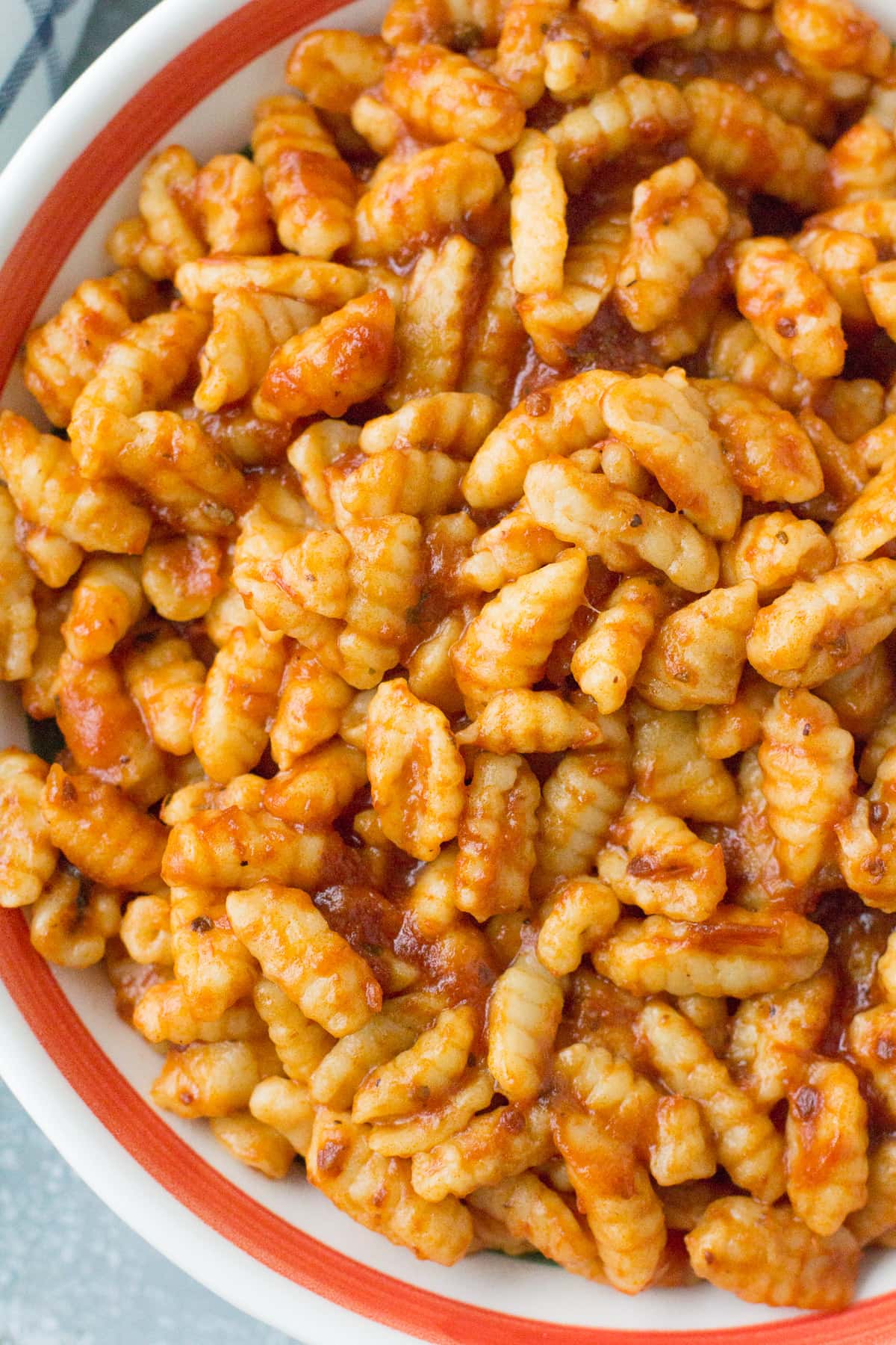 A close up of Homemade Ricotta Cavatelli in a red lined pasta bowl