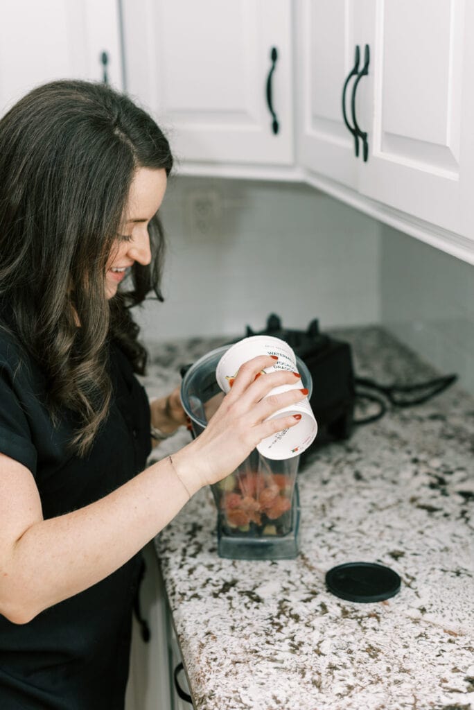 Pouring daily harvest into a blender to be blended