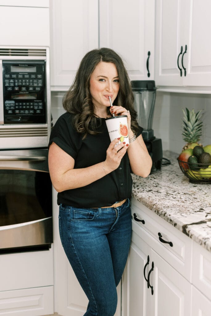 Elizabeth Marino drinking a daily harvest smoothie in a kitchen