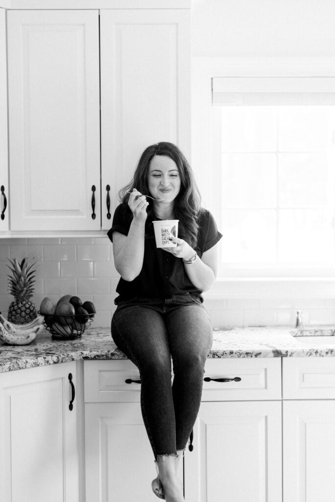 A girl eating daily harvest scoops in her kitchen