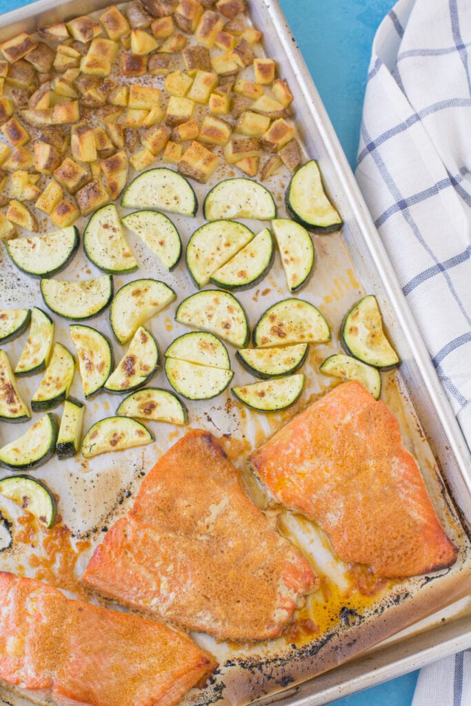 A sheet pan with honey sriracha salmon recipe, zucchini and potatoes