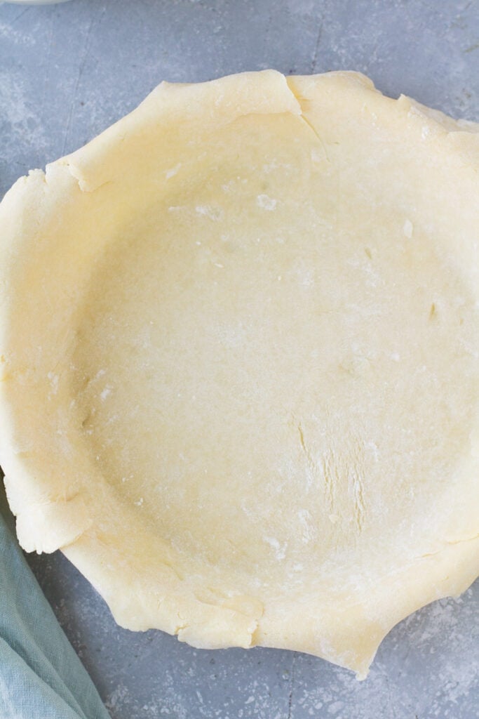 an empty pie shell in a glass pie plate before being filled
