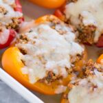 A close up of quinoa stuffed peppers in a white dish