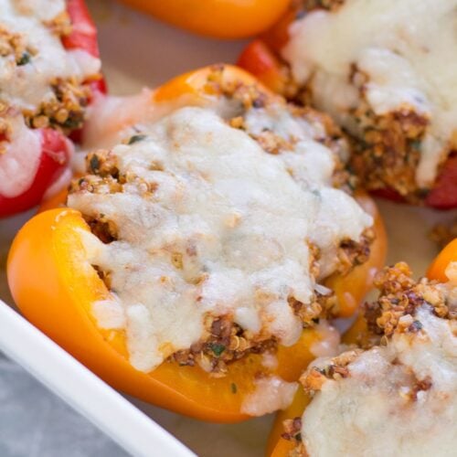A close up of quinoa stuffed peppers in a white dish