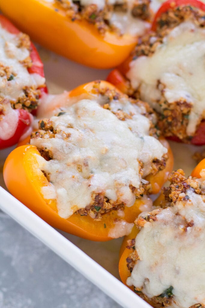 A close up of quinoa stuffed peppers in a white dish