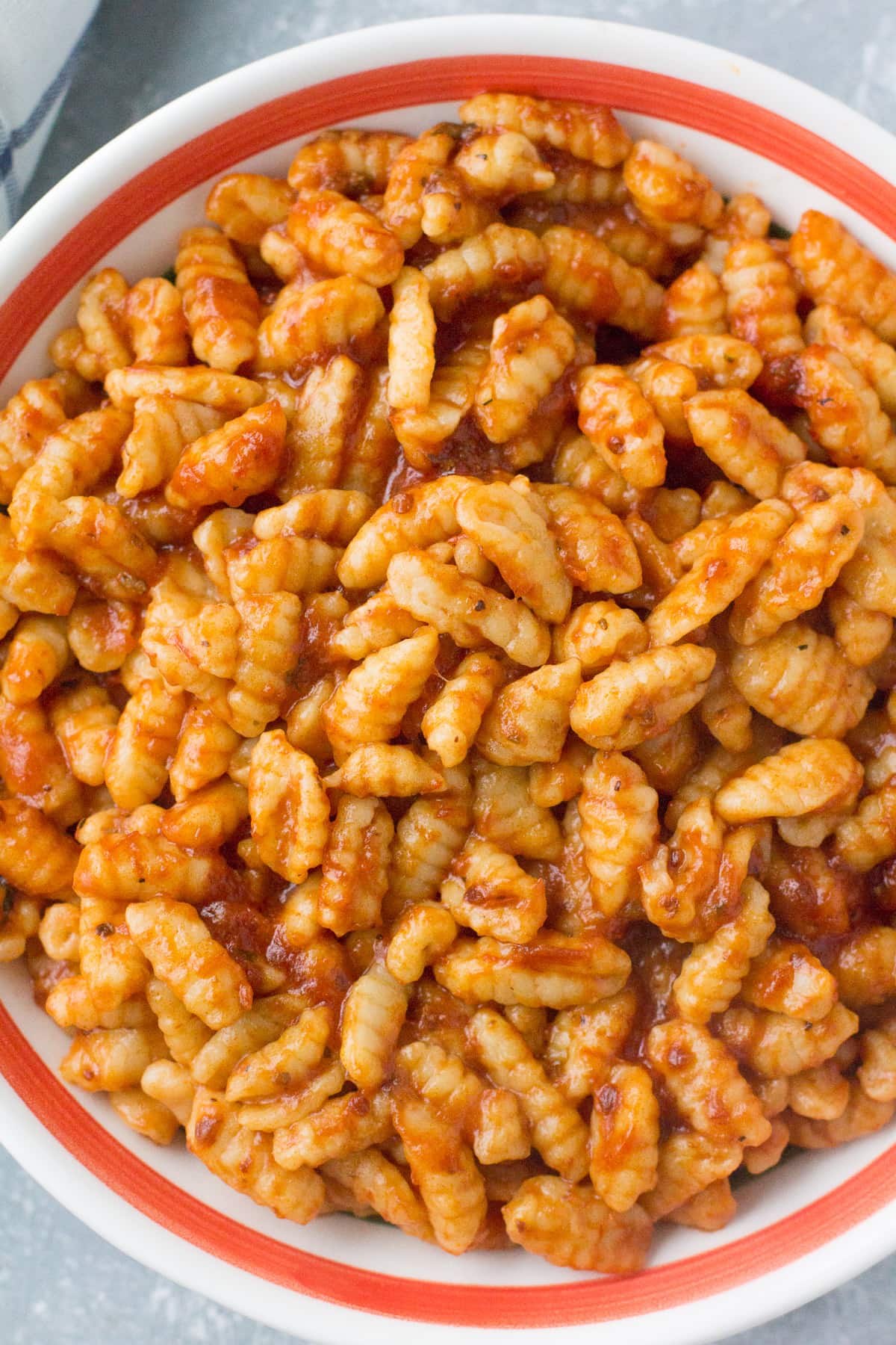 A bowl of homemade ricotta cavatelli tossed with tomato sauce.