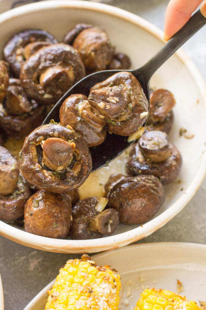 A spoon scooping out a serving of balsamic mushrooms