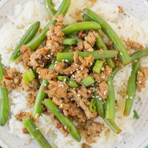Spicy Ground Turkey Stir Fry on a white plate on a blue background