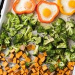 Sheet Pan Breakfast with potatoes, broccoli, and eggs on a parchment lined baking sheet.