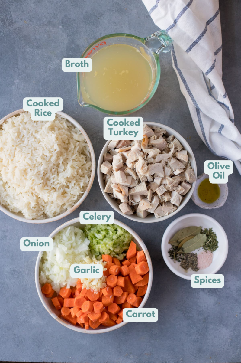 Ingredients for Leftover Turkey Soup on a grey background. everything is in small white bowls