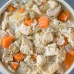 A close up of leftover turkey soup in a grey bowl