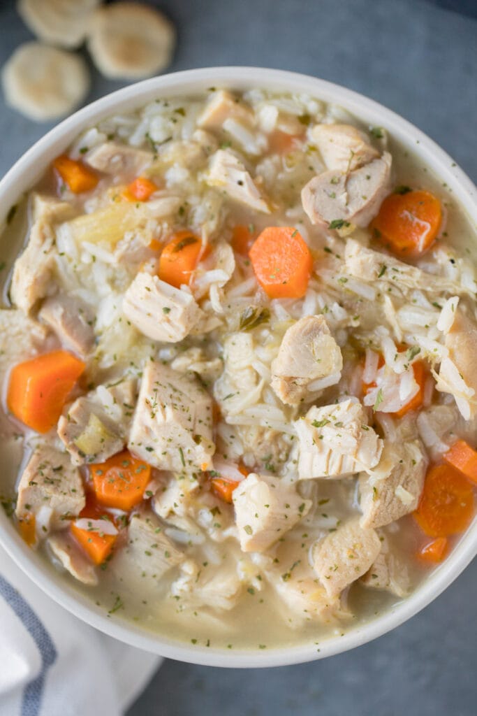 A close up of leftover turkey soup in a grey bowl