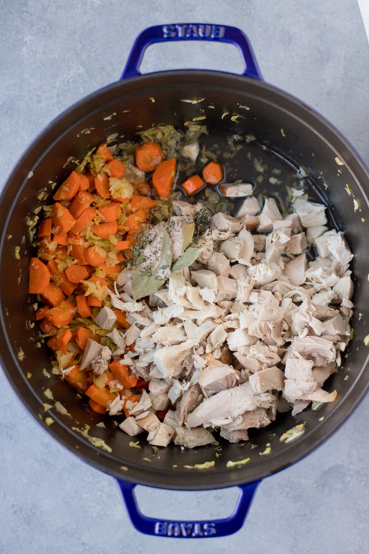 Most of the ingredients for leftover turkey soup in a large pot before being fully cooked