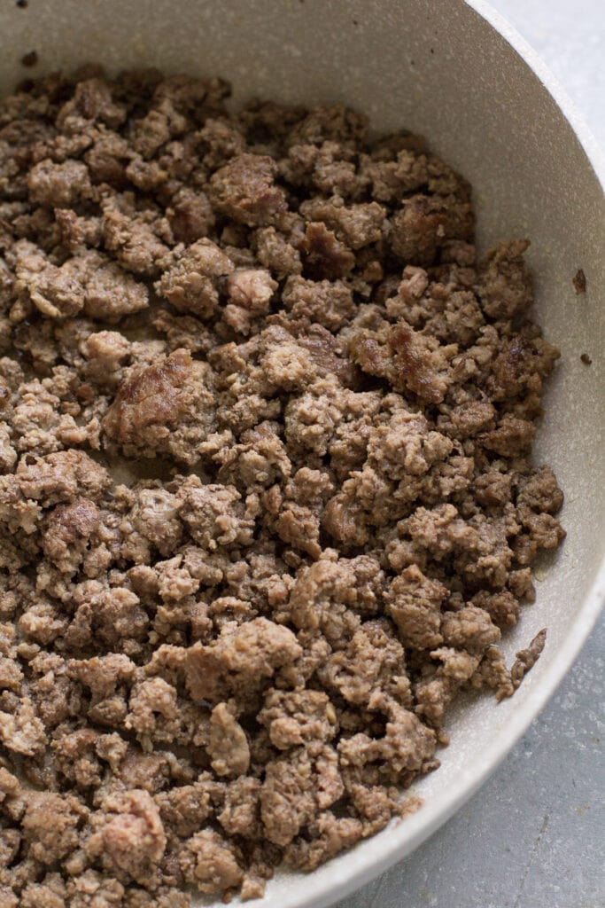 ground beef in a white pan being sauted for ground beef and sweet potato chili