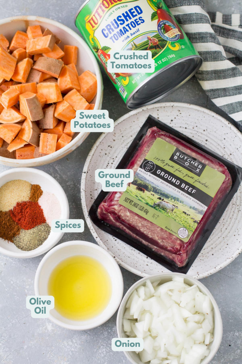 Ingredients for groun dbeef and sweet potato crockpot chili laid out in small white bowls on a grey background