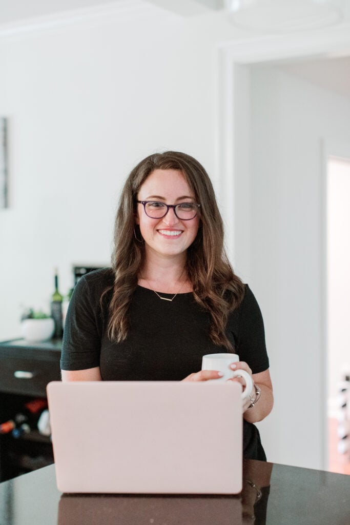 A girl standing at a laptop looking up