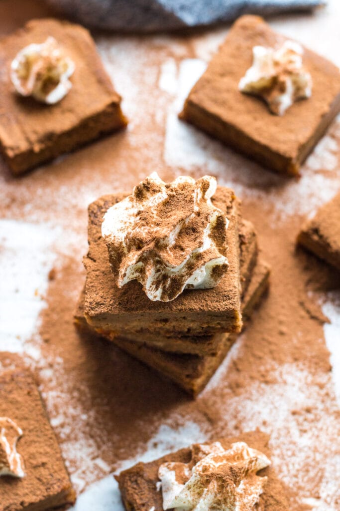 A top down image of a healthy gluten free pumpkin bar with whipped cream on top.