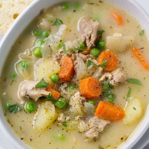A cozy bowl of Healthy Turkey Pot Pie Soup with bread off to the side