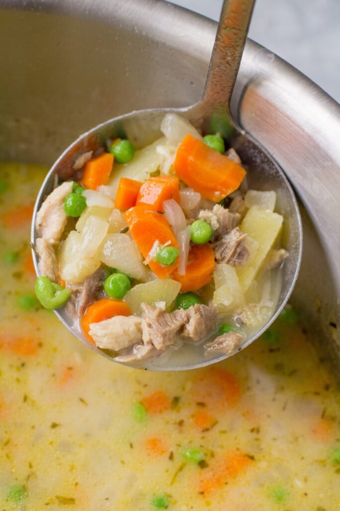 A close up of a ladle of Turkey Pot Pie Soup
