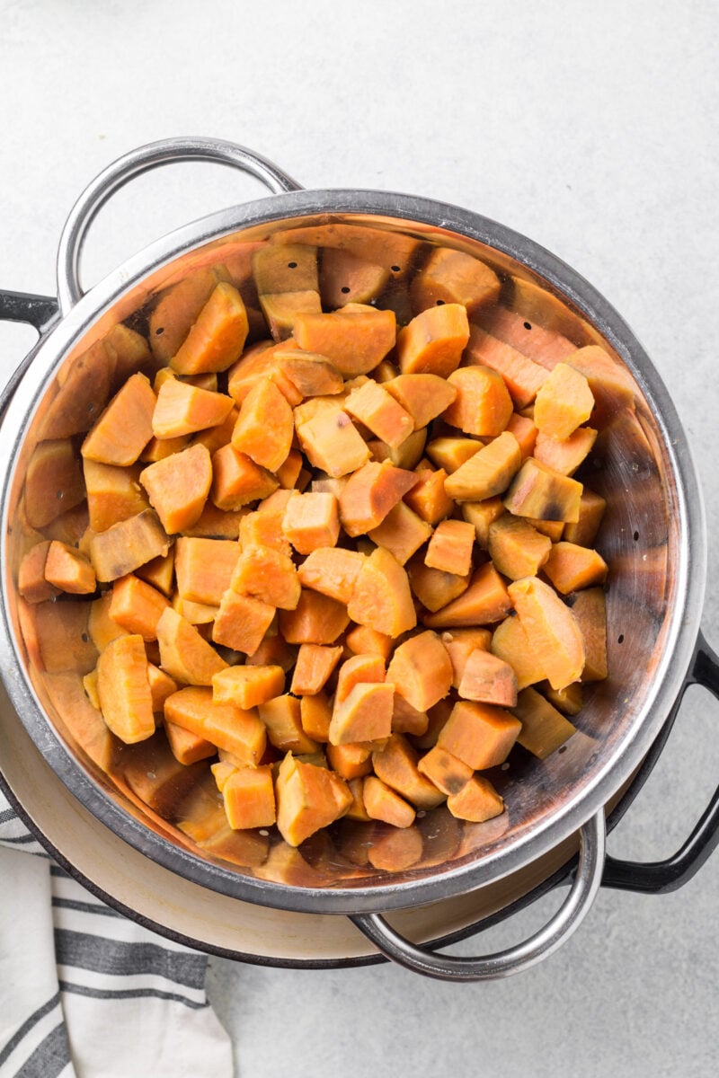 Boiled sweet potato cubes in a strainer. 