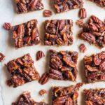 An overhead shot of Healthy Pecan Pie Bars cut on parchment paper