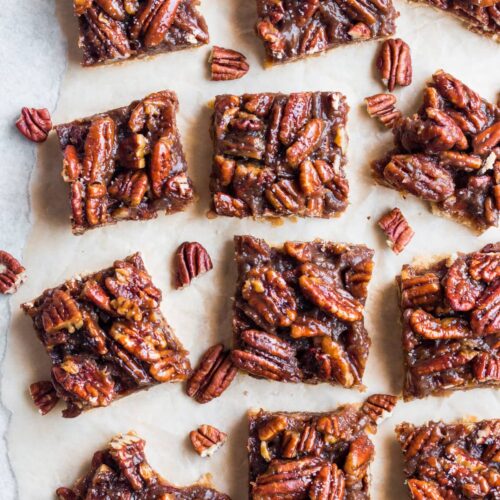 An overhead shot of Healthy Pecan Pie Bars cut on parchment paper