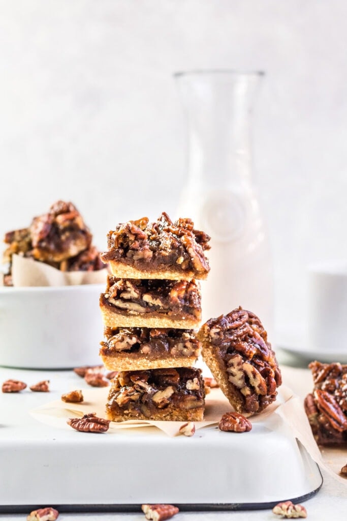 Healthy Pecan Pie Bars stacked on top of one another with a white background