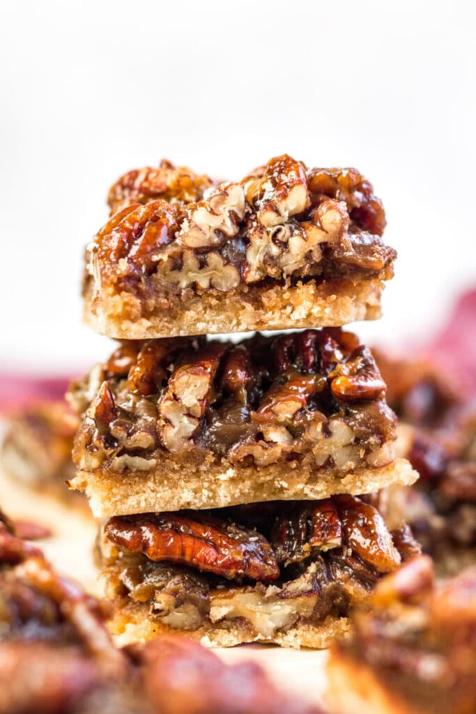 Paleo Pecan Pie Bars stacked on top of one another with a white background