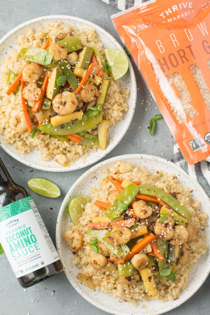 An overhead image of two plates of easy shrimp stir fry on white plates