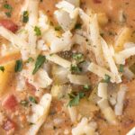 A close up of Cheeseburger Soup in a white soup bowl