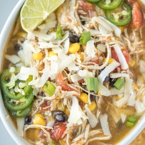 Chicken tortilla soup in a white bowl on a grey background