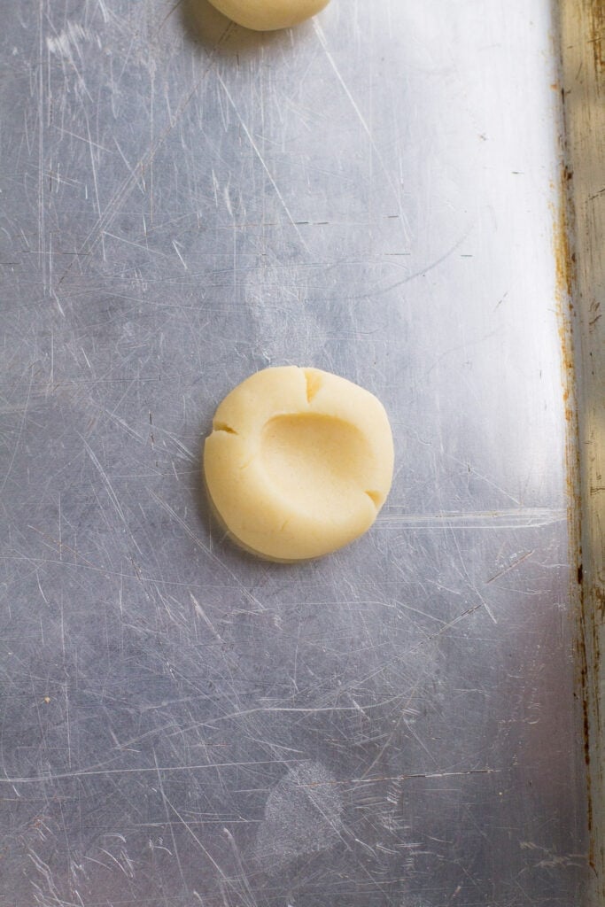 thumbprint cookies on a metal baking sheet before going in the oven