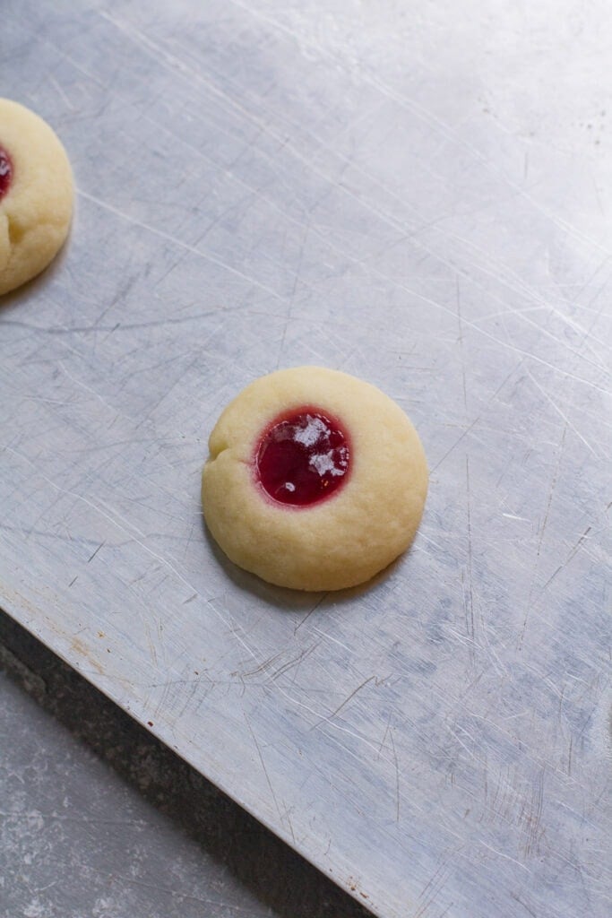 a classic thumbprint cookie fresh out of the oven on a baking sheet