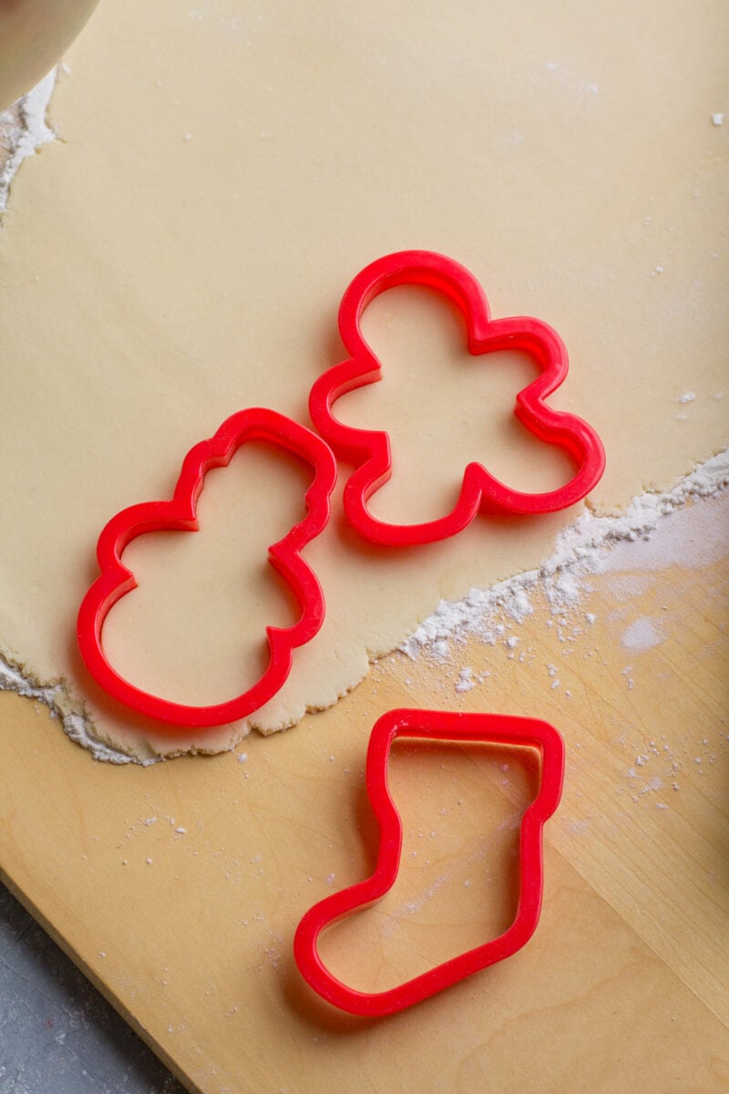 Cookie cutters sitting on rolled out sugar cookie dough.