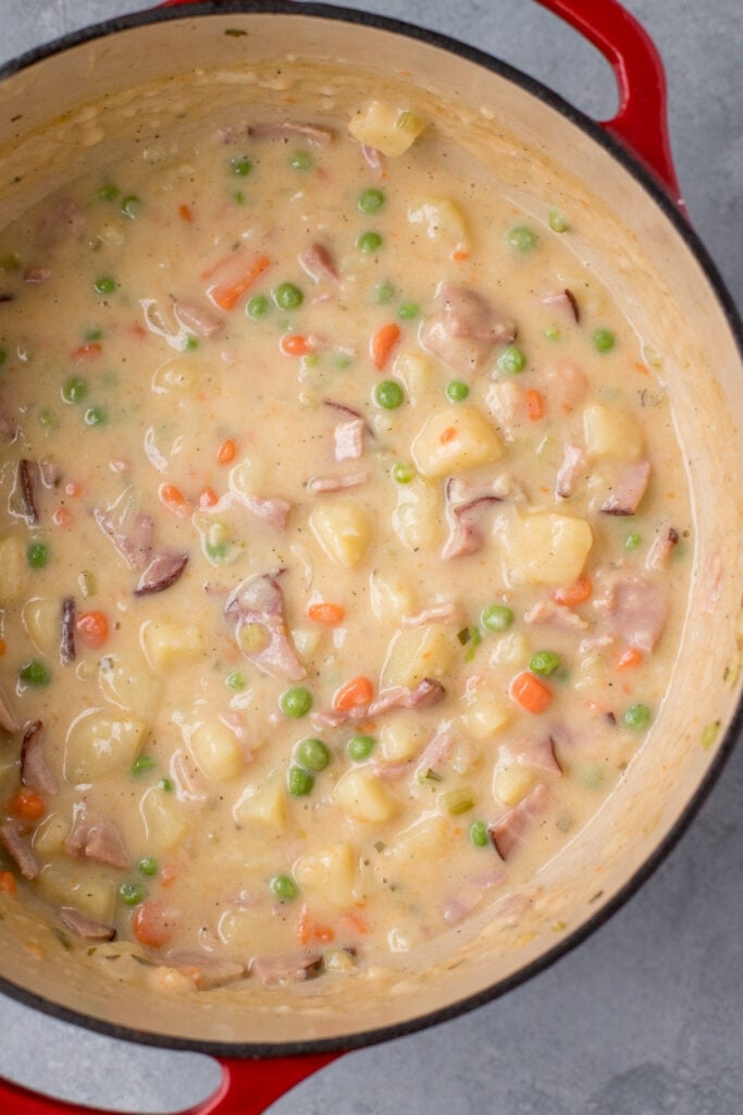 An overhead shot of Ham & Potato Soup in a red dutch oven