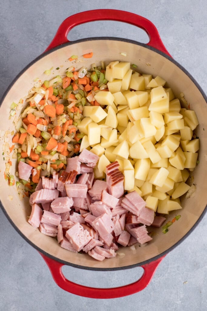 An overhead image of ham and potato soup segmented out in a dutch oven