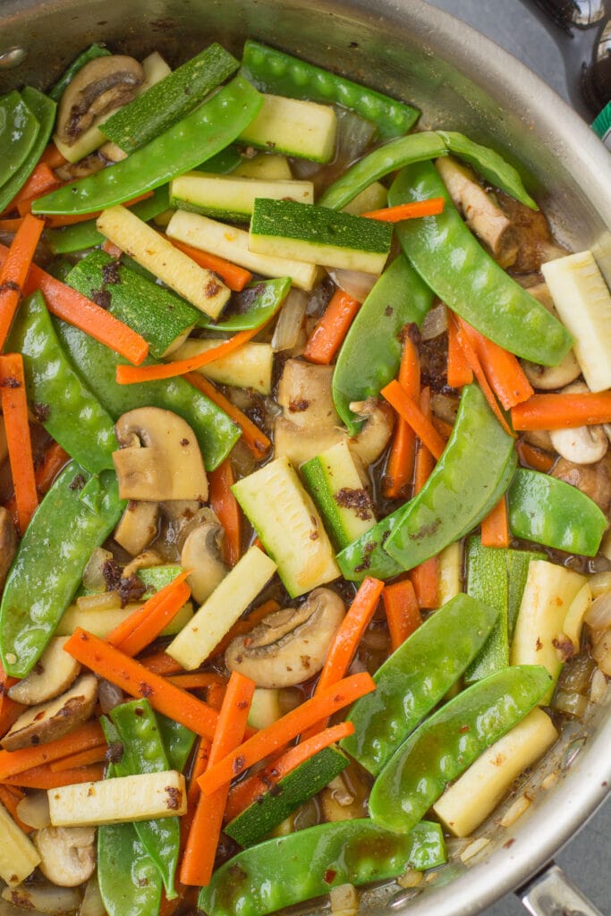 veggies for shrimp stir fry being mixed together in a pan