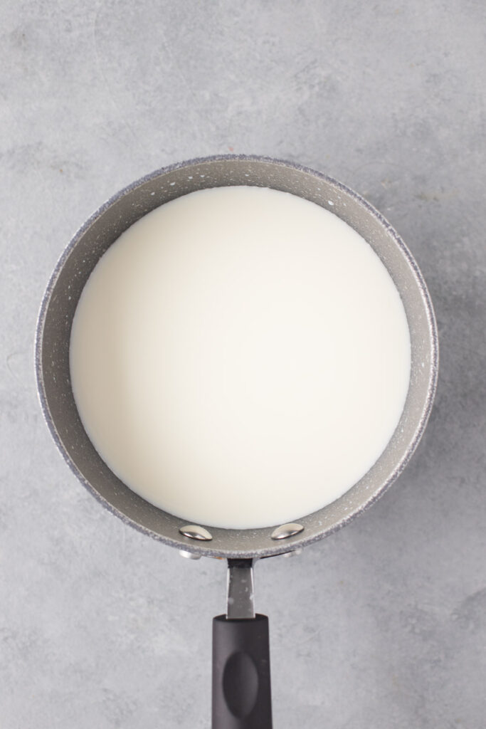 A grey pan filled with milk for healthy hot chocolate