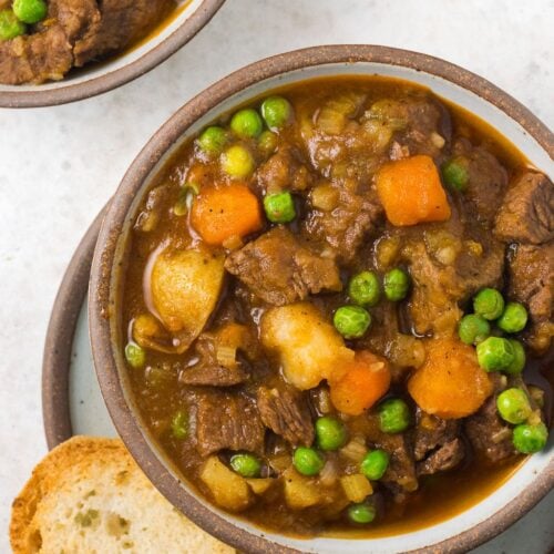 A bowl of instant pot beef stew on a light grey background