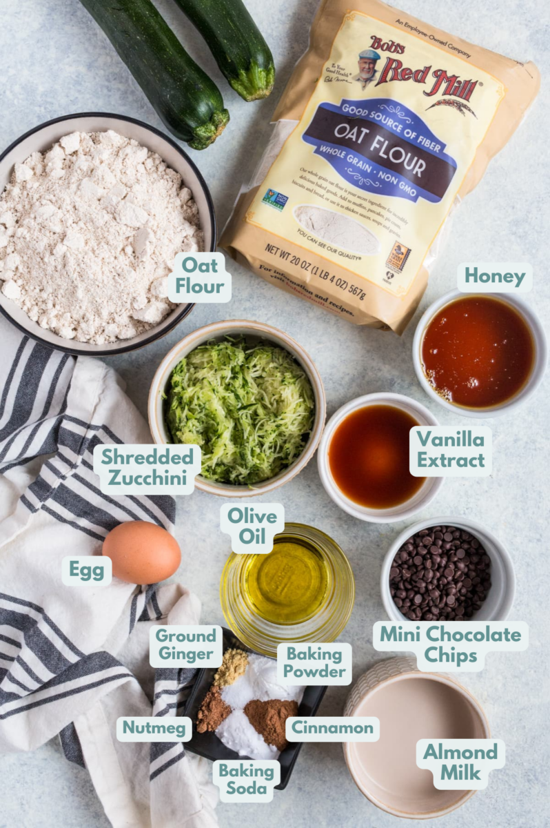 Ingredients for Healthy Zucchini Bread in small white bowls on a grey background