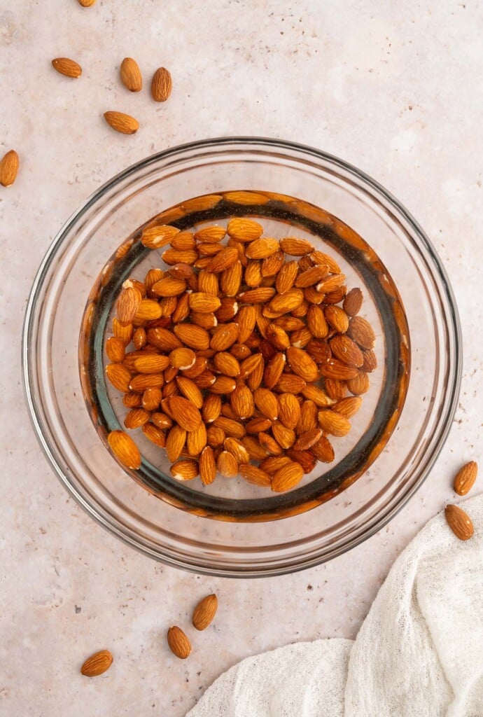 An overhead shot of a bowl of almonds that have been soaking in water.