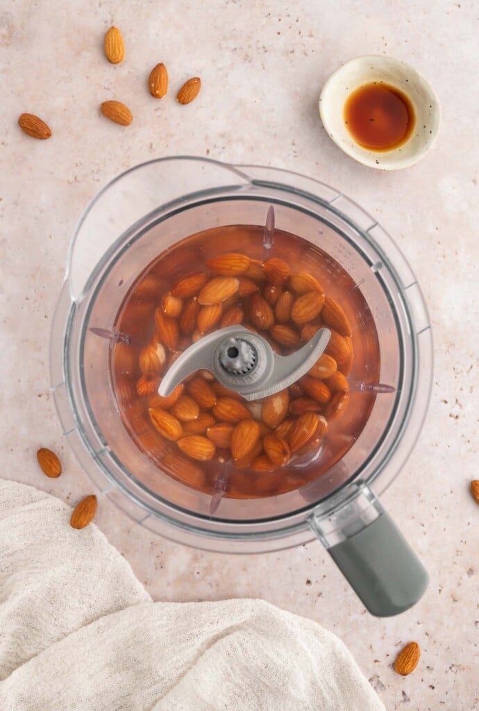 Soaked almonds and water in a blender before blending.