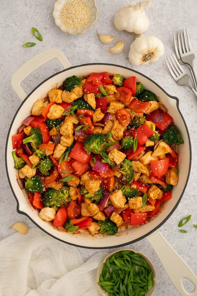 Sweet and sour chicken in a pan all mixed together.
