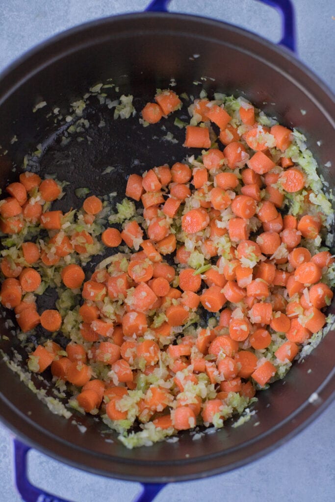 Lentil Soup getting started in a dutch oven with vegetables: carrots, onion, celery