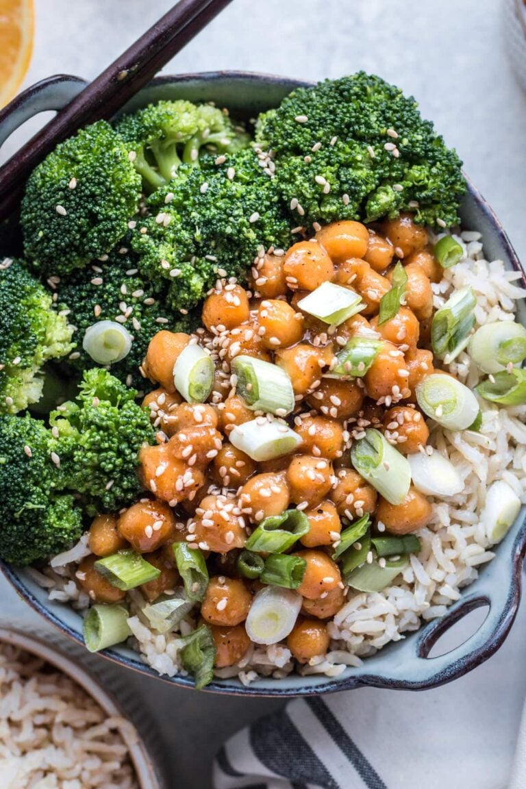 A close up of healthy vegan orange chicken in a bowl filled with broccoli and rice