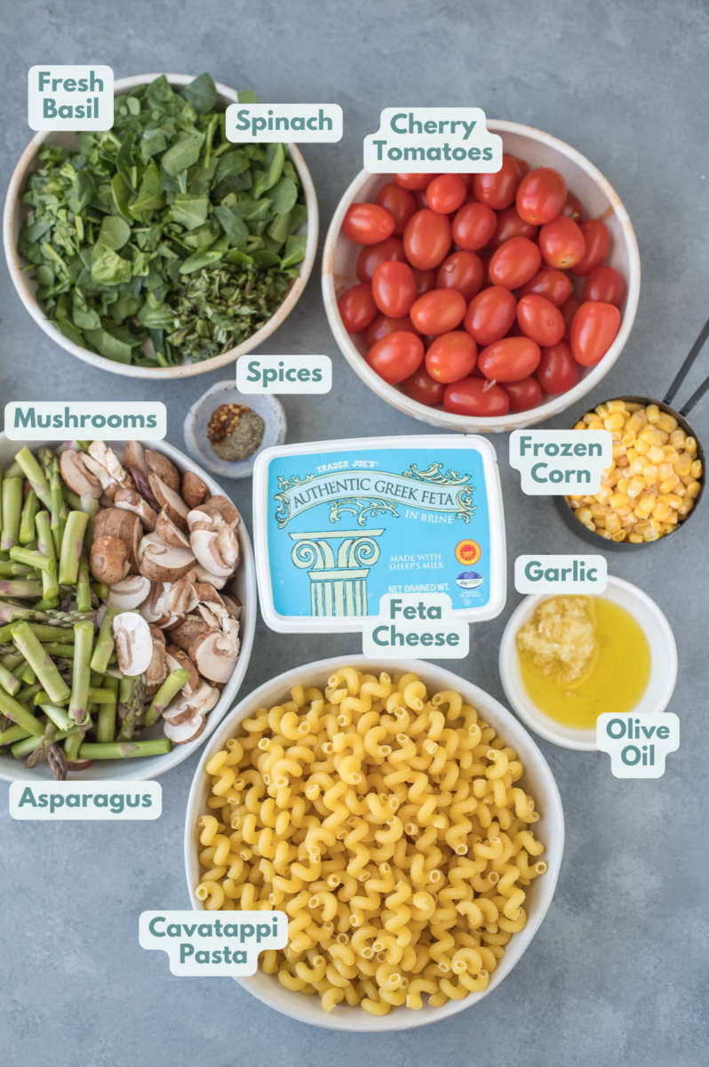 Ingredients for feta pasta in small white bowls: spinach, tomatoes, feta, corn, olive oil, garlic, pasta, asparagus, mushrooms, pepper