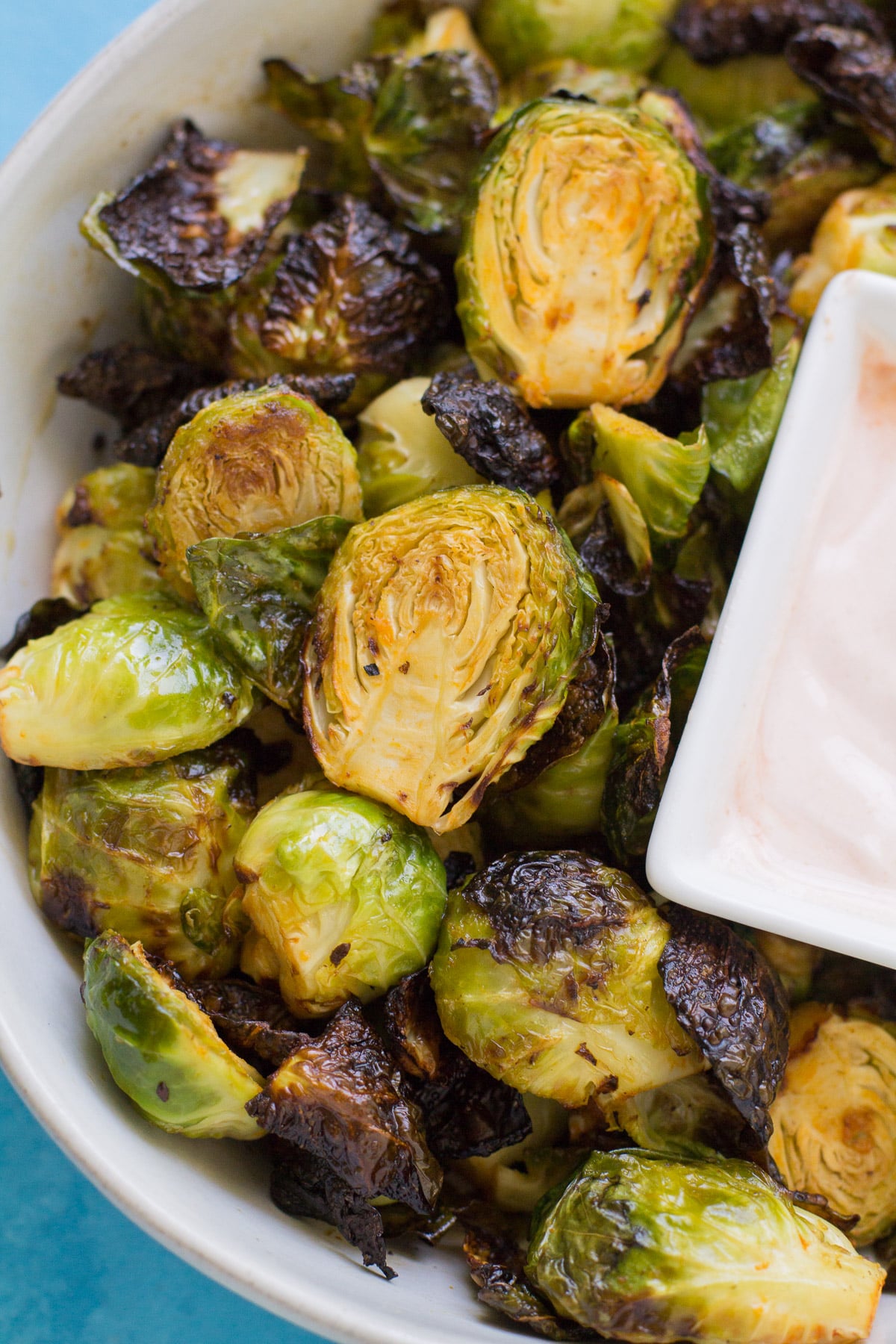 An overhead image of buffalo brussels sprouts in a white bowl