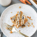 Carrot Cake Baked Oatmeal on a white speckled plate with a gold fork