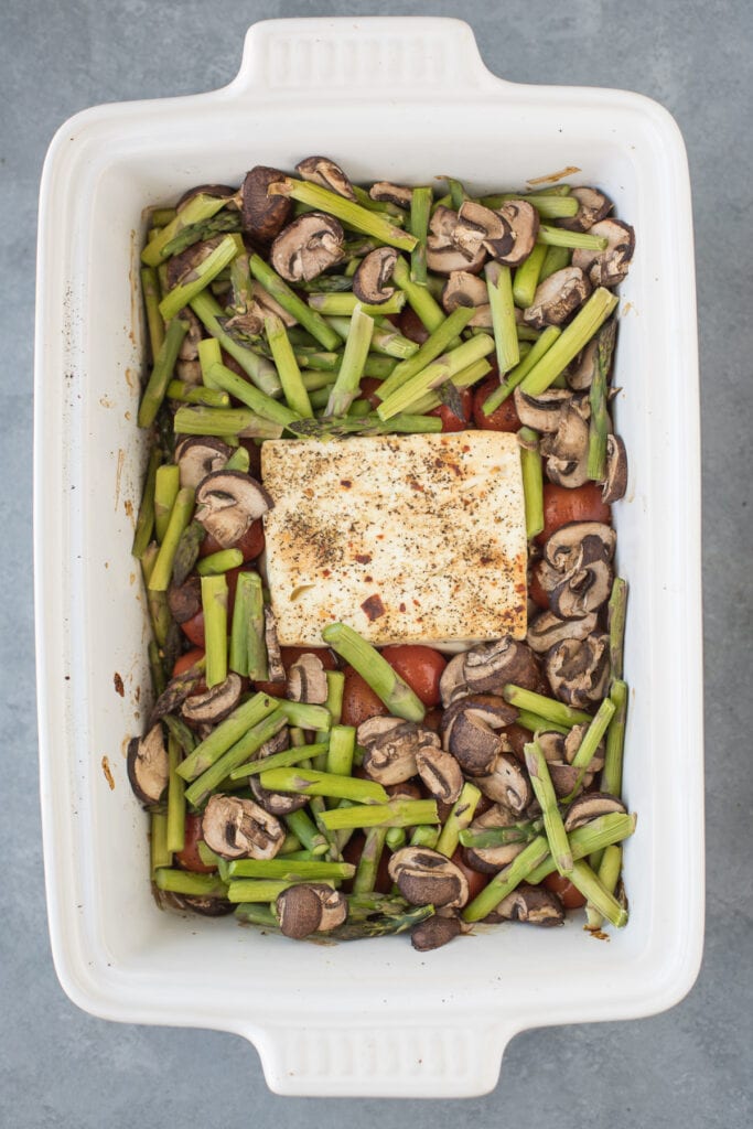 White baking dish filled with all the veggies for feta pasta